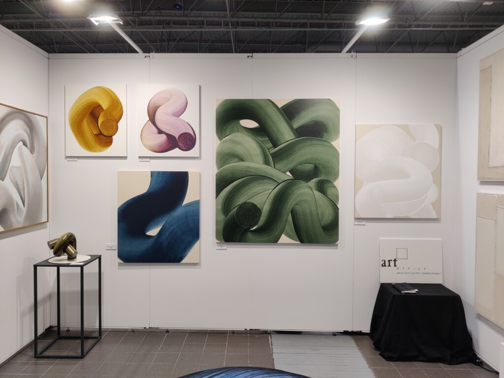 Obrazy abstrakcyjne Nikodema Szpunara, Marcina Brodowskiego i Pawła Lubińskiego w przestrzeni stoiska galerii Art Office.