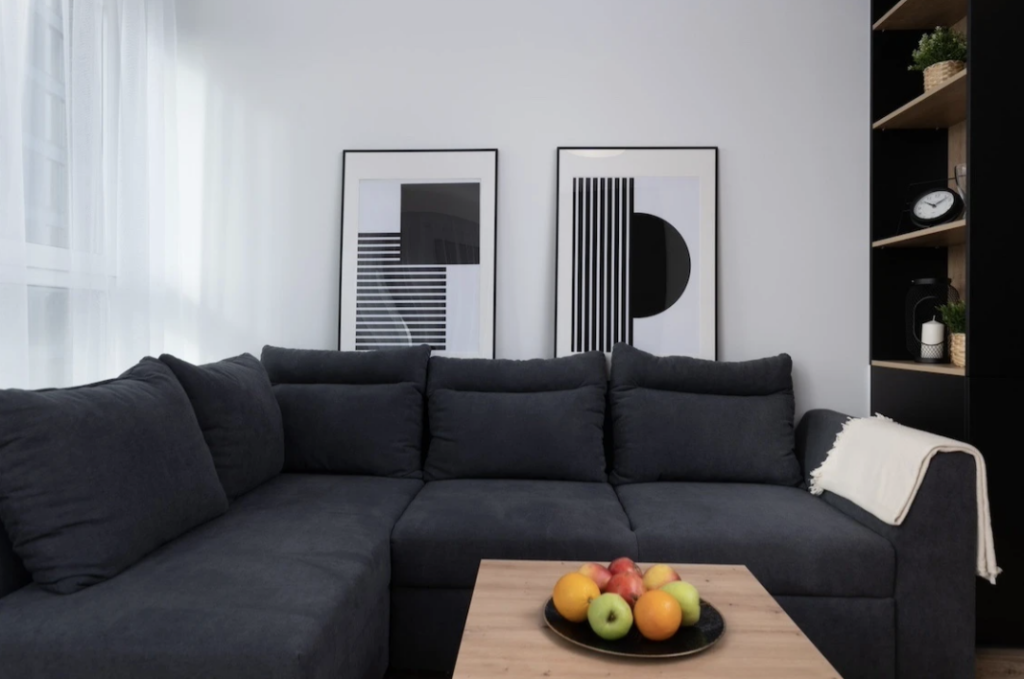 Rozświetlone nowoczesne wnętrze ze stylowymi obrazami abstrakcyjnymi nad kanapą