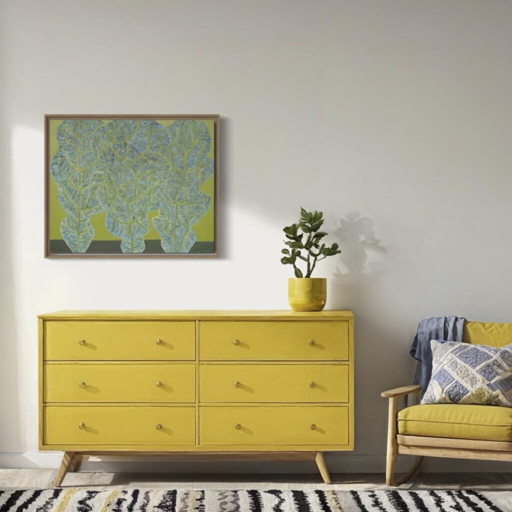 Zielony obraz z liśćmi wiszący nad żółtą komodą w przytulnym domowym wnętrzu