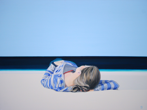 Widok na morze i kobietę leżącą na plaży.