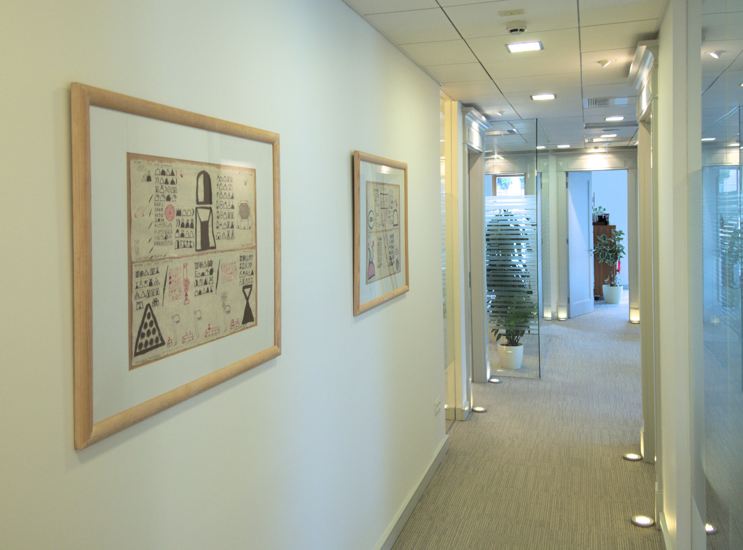 Stonowane obrazy abstrakcyjne wiszące w przestrzeni nowoczesnego, jasnego biura.